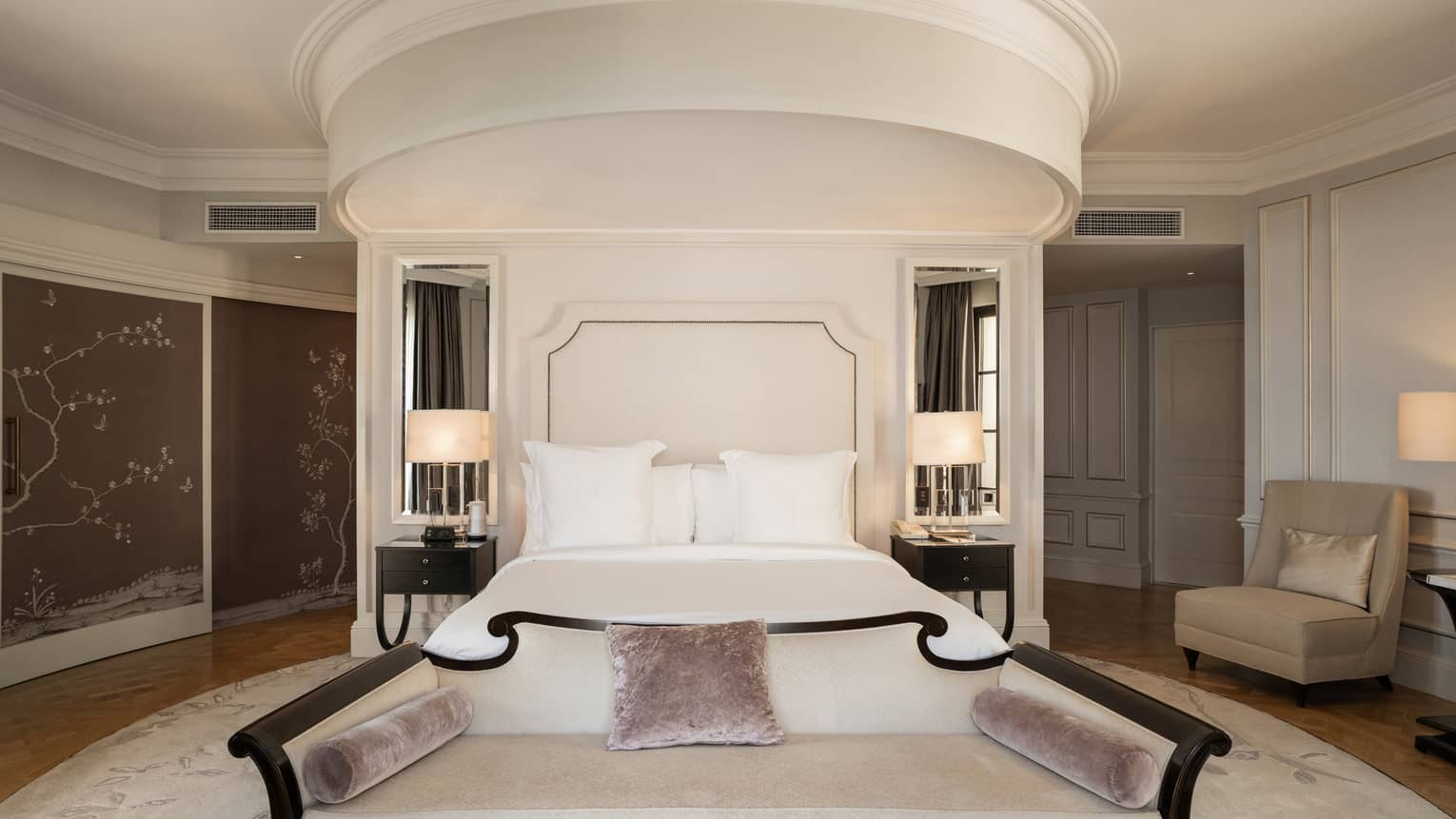 Elegant bedroom with king bed and curved wall with crown molding