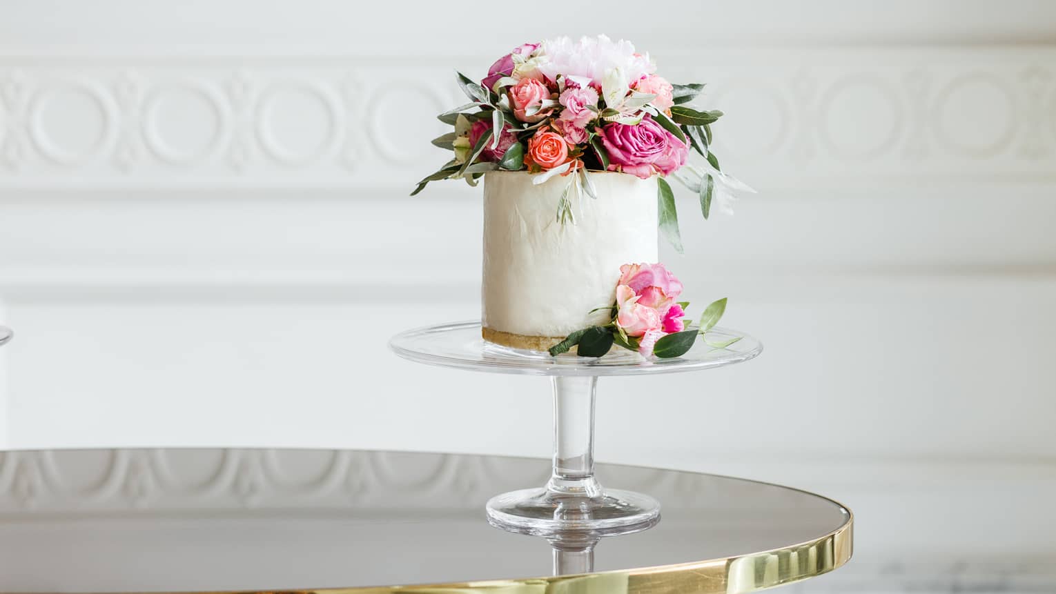 Elegant small white wedding cake topped with fresh pink and white roses 