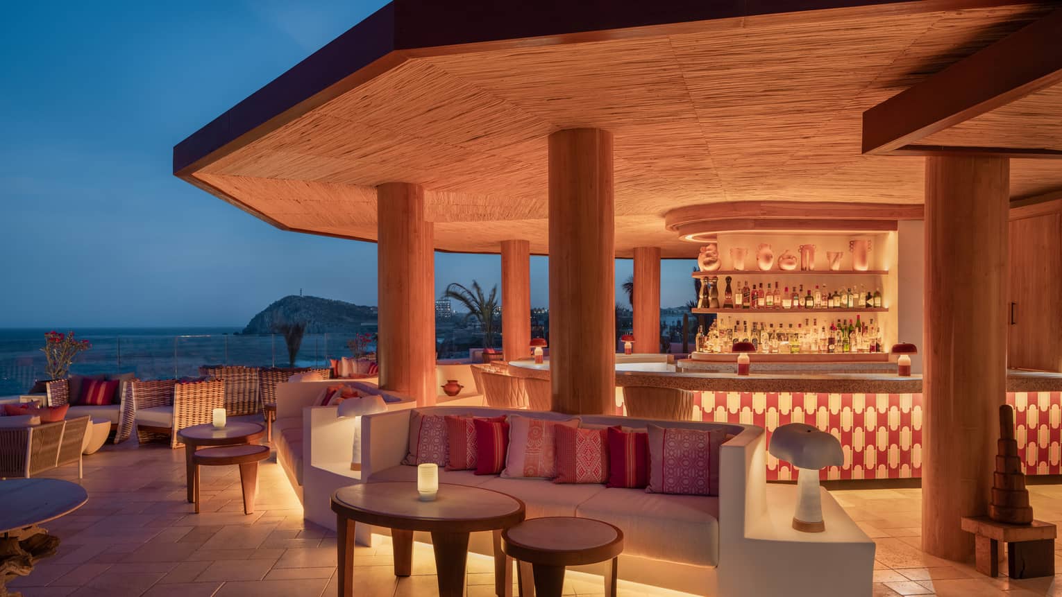 Illuminated ocean-view bar at night at Four Seasons Resort and Residences Cabo San Lucas