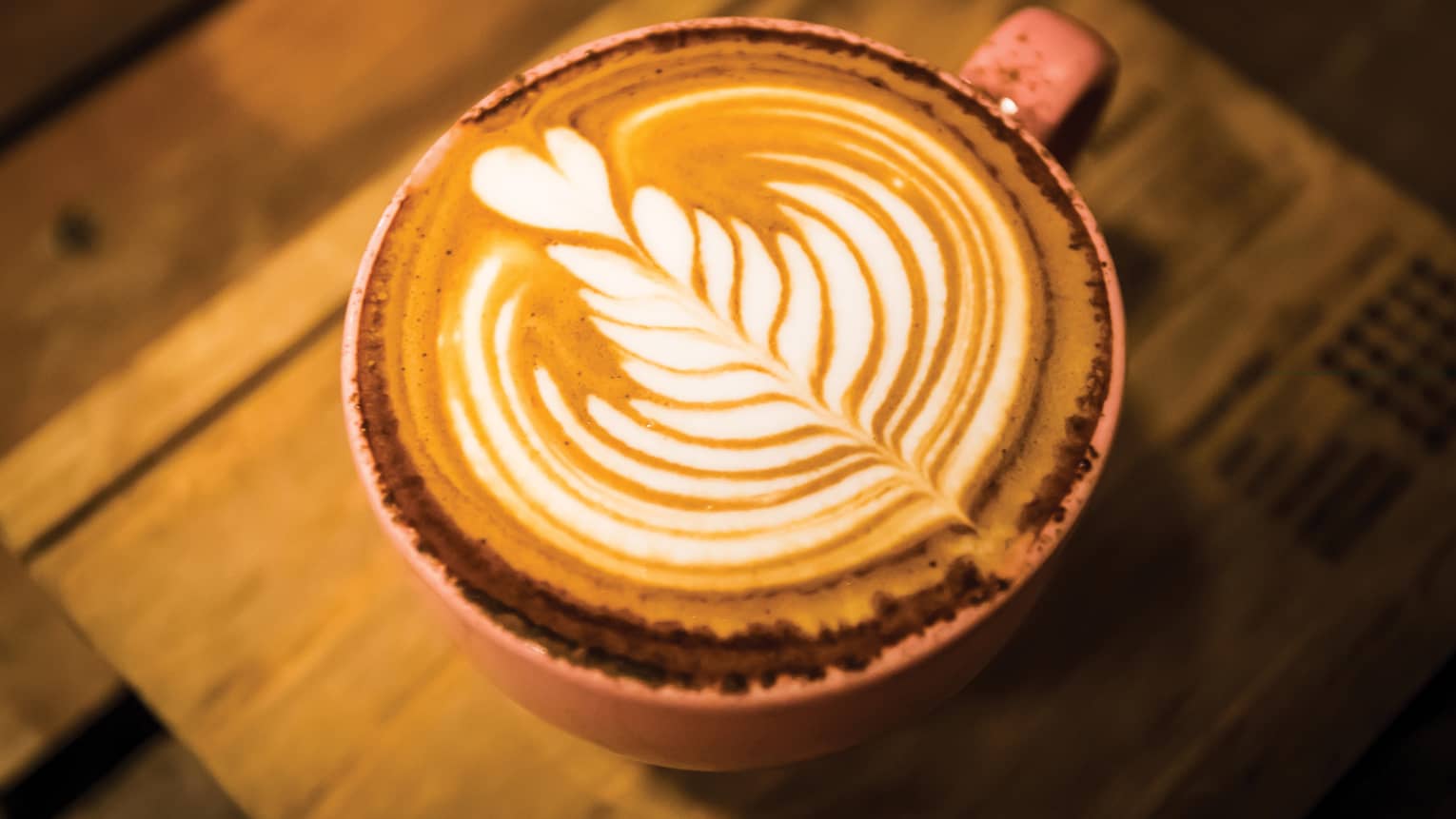 Close-up of latte coffee with flower design in foam