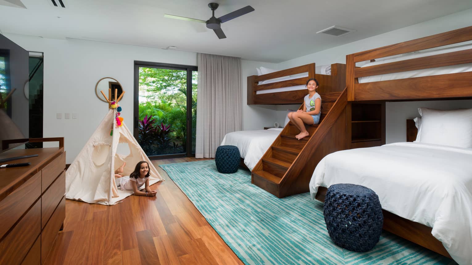 Two kids play in bedroom with bunk beds, tent