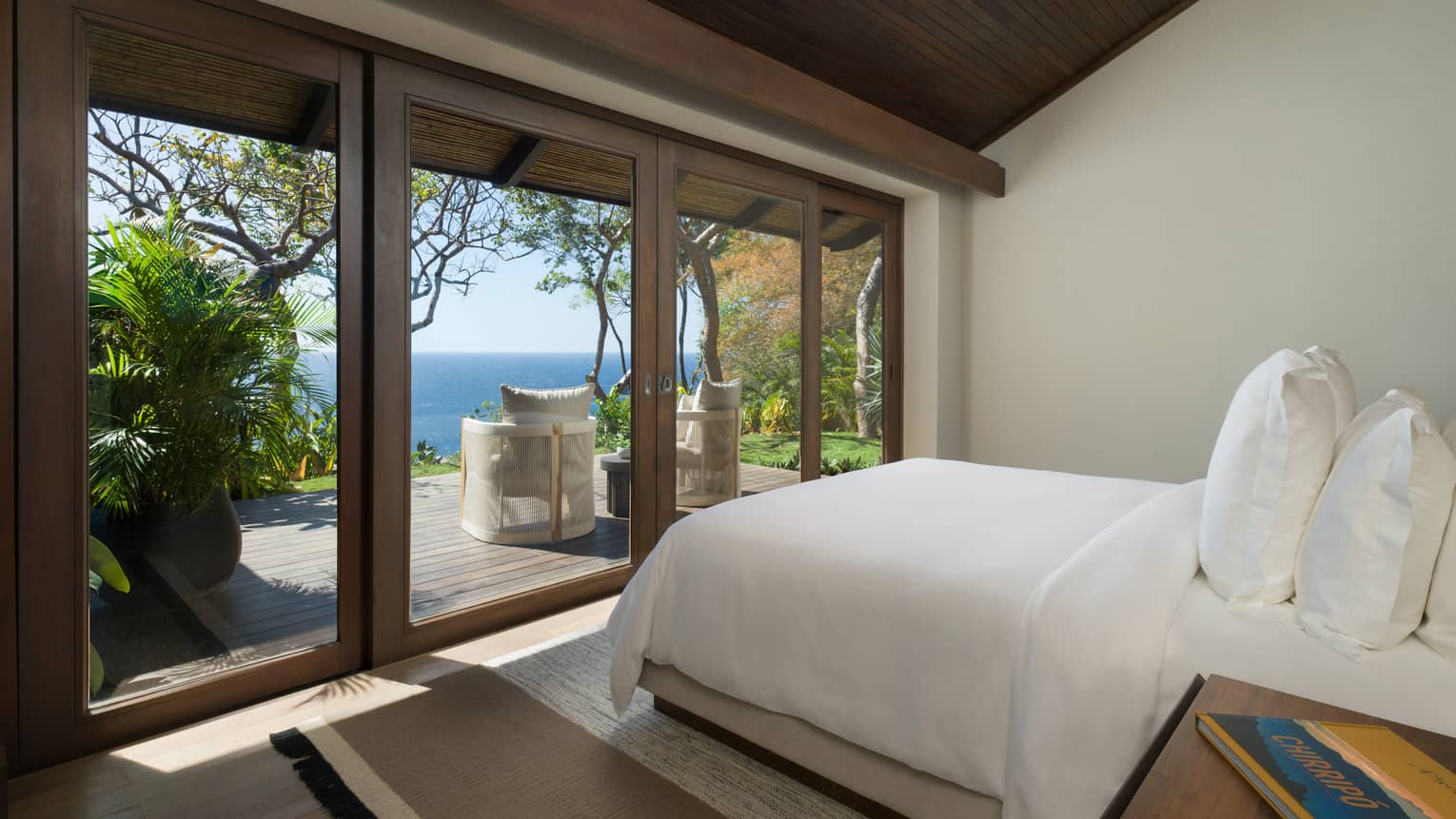 Bedroom with wall of windows looking out to sea