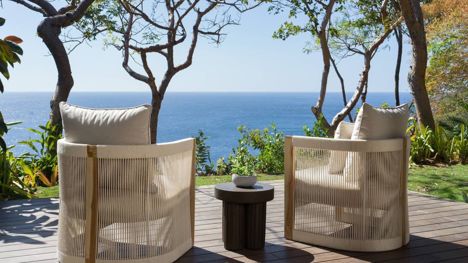 Two chairs on wooden deck facing the ocean