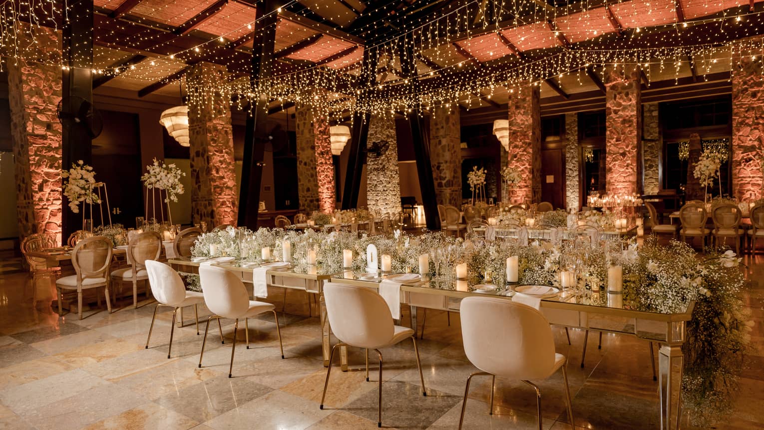 Ornately decorated function room arranged banquet style with stone pillars