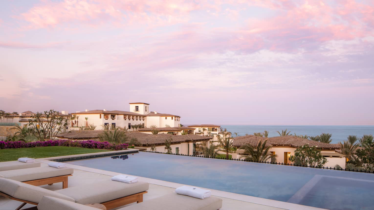 View of the ocean from a private luxury villa terrace, complete with a pool and lounge chairs, at Four Seasons Resort Cabo San Lucas