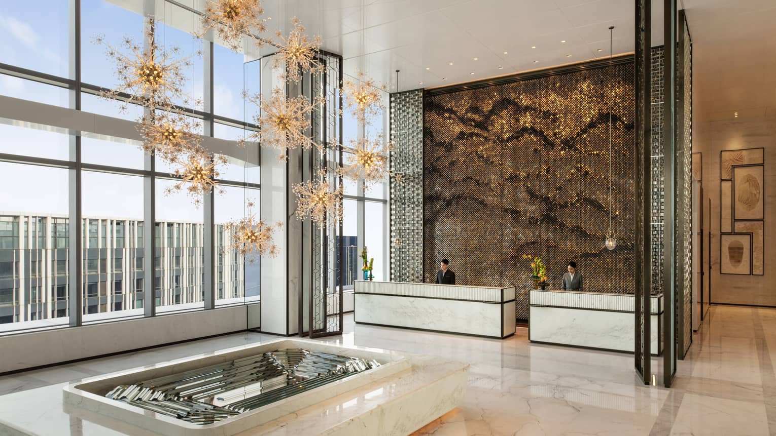 Elegant lobby of Four Seasons Hotel Dalian, with marble floors and floor-to-ceiling windows