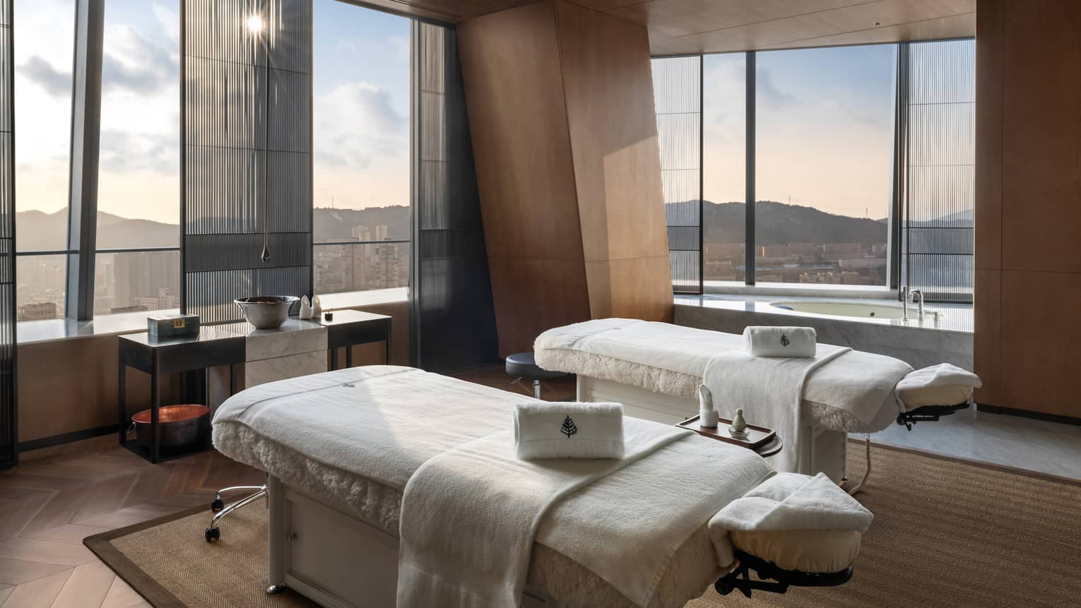 Spa treatment room with two treatment beds and expansive views of Dalian, China