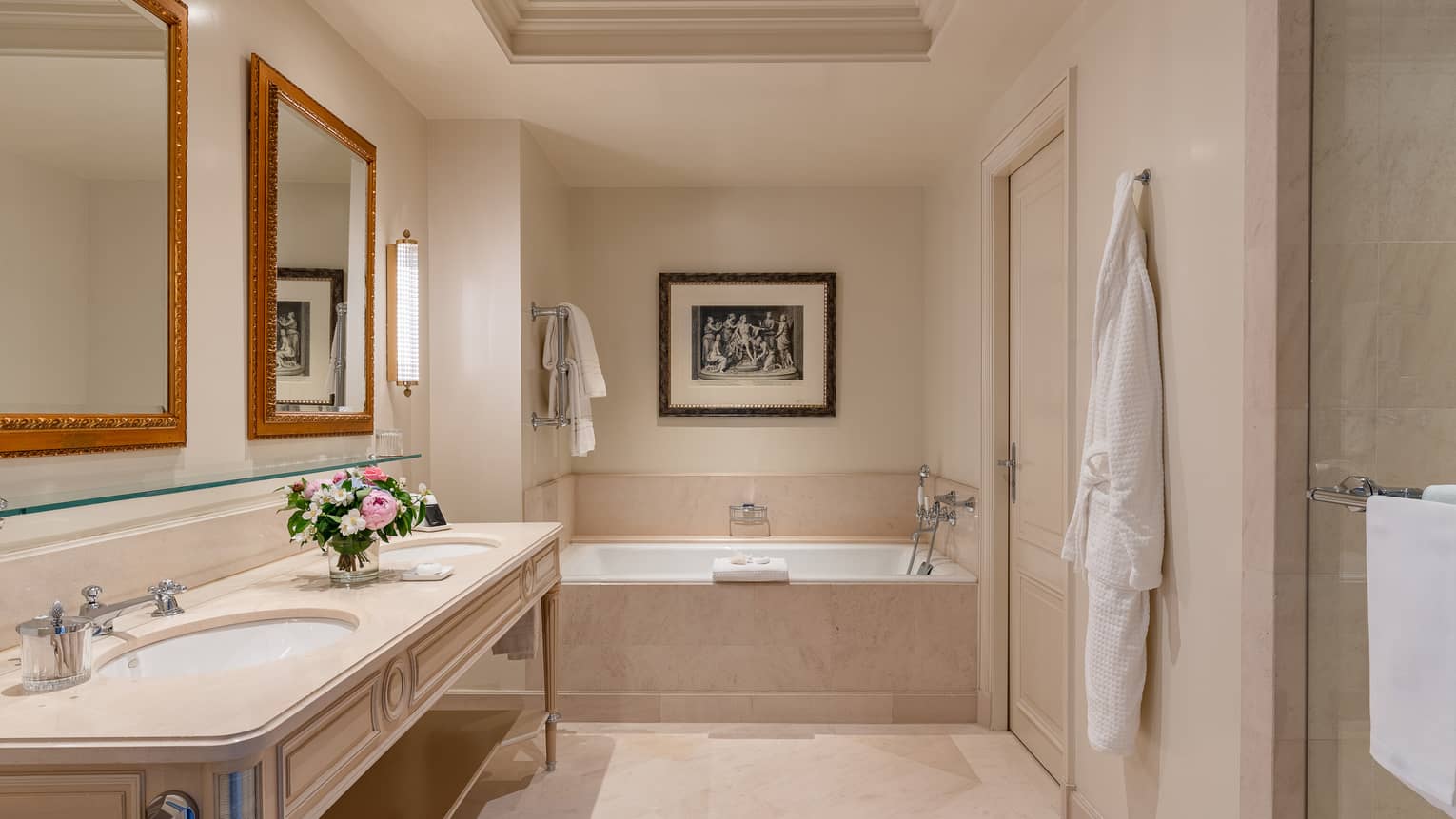 Luxury hotel suite bathroom with two sinks, tub and hanging Four Seasons bath robe at Four Seasons Hotel des Bergues, Geneva