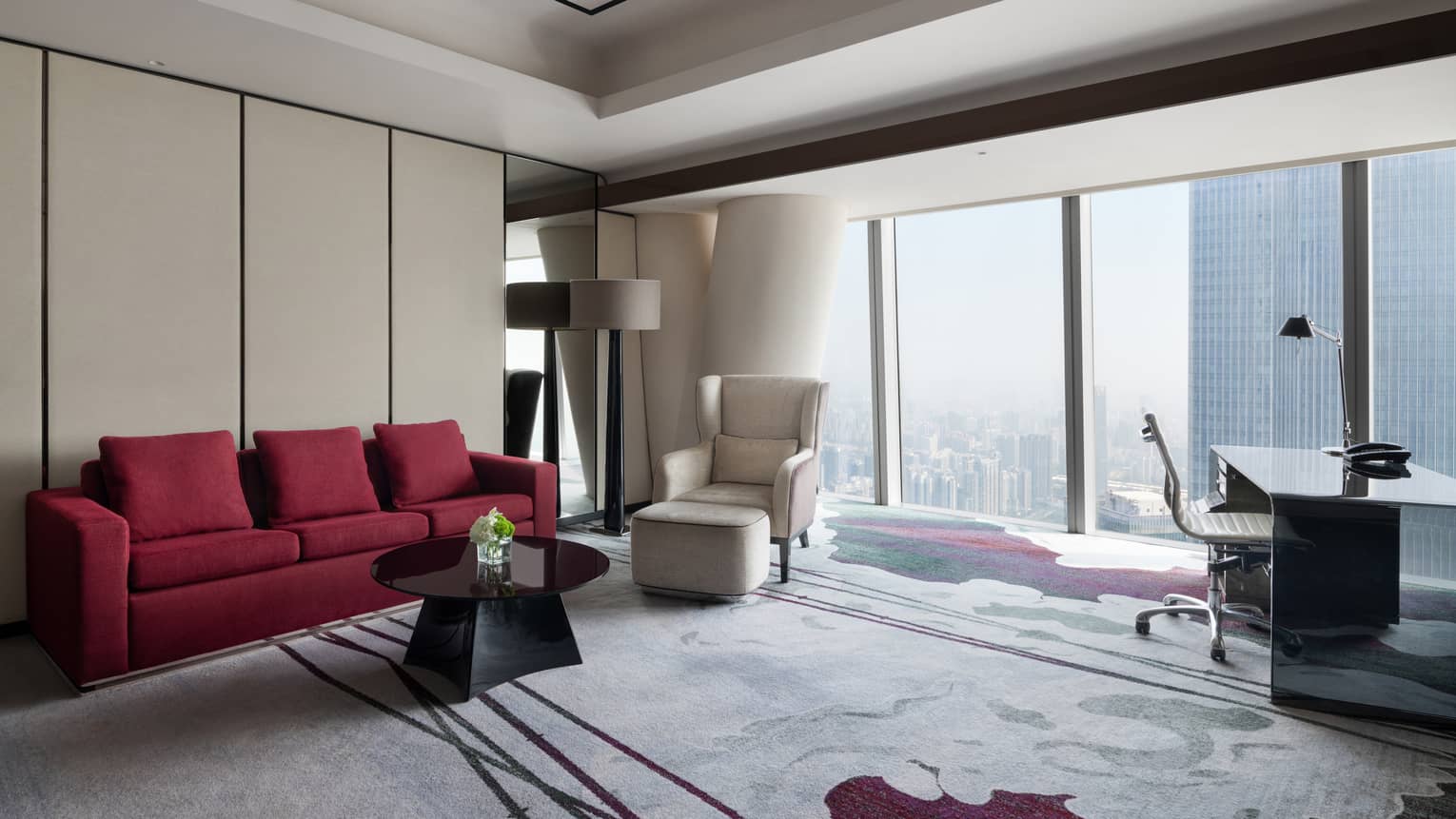 Deluxe King River View Suite living area with red sofa and floor-to-ceiling windows