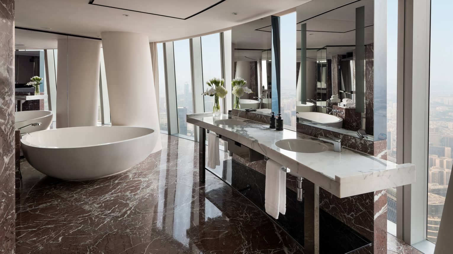 Premier King Bathroom with white marble double vanity, large soaking tub and floor-to-ceiling windows