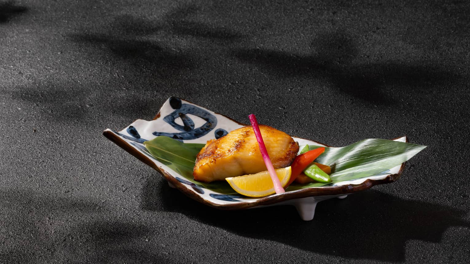 Grilled marinated black cod with miso sauce on banana leaf