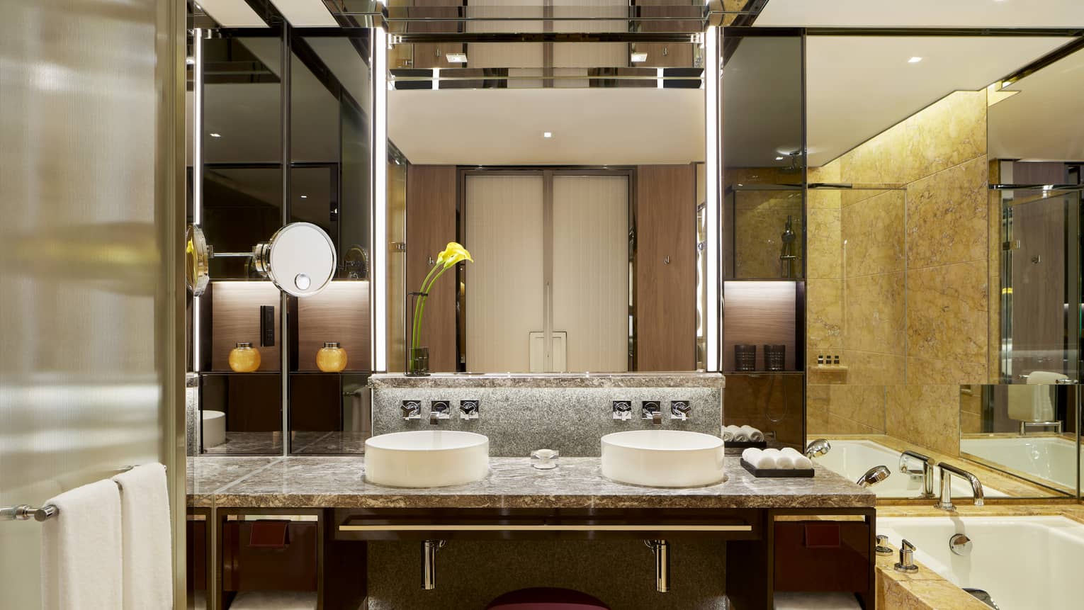 Bathroom with double vanity, tub, wall of mirrors