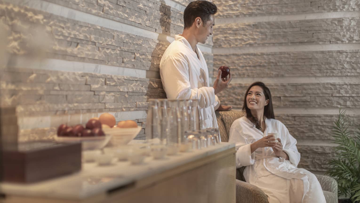 Man and women relax at spa in bathrobes