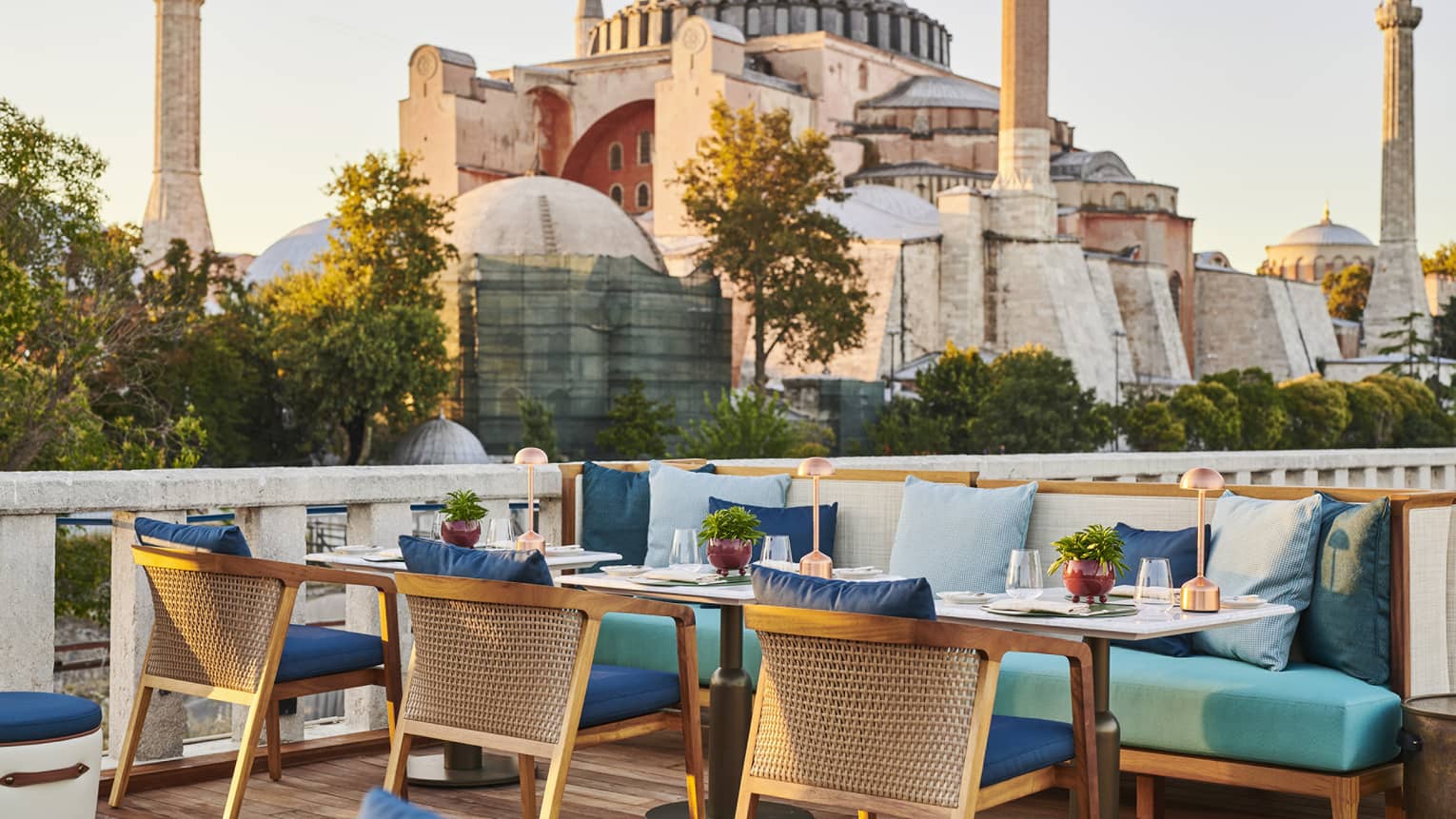 Terrace with outdoor table and blue cushioned chairs and the Blue Mosque in the background