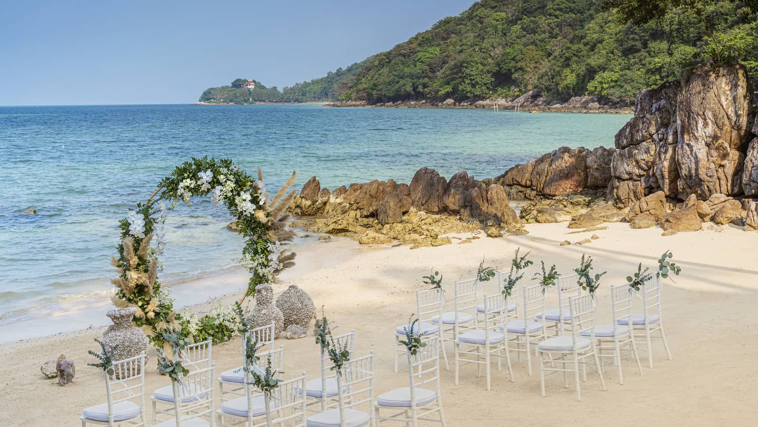 Wedding setup on beach with round flower arch
