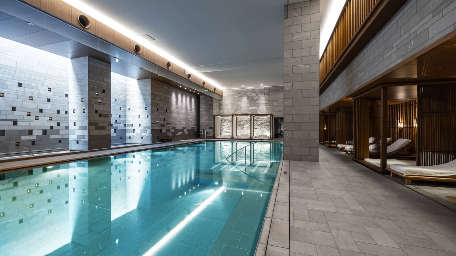 Indoor spa pool with chaise longues and grey columns