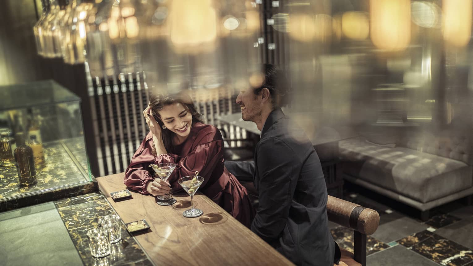 Laughing couple enjoys martinis at The Lounge 