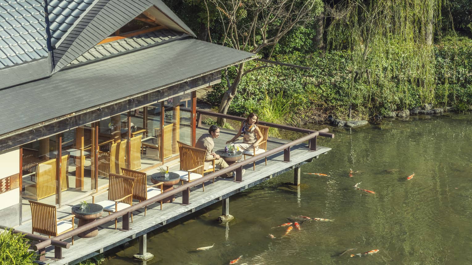 Couple enjoys tea on FUJU's terrace overlooking the koi pond