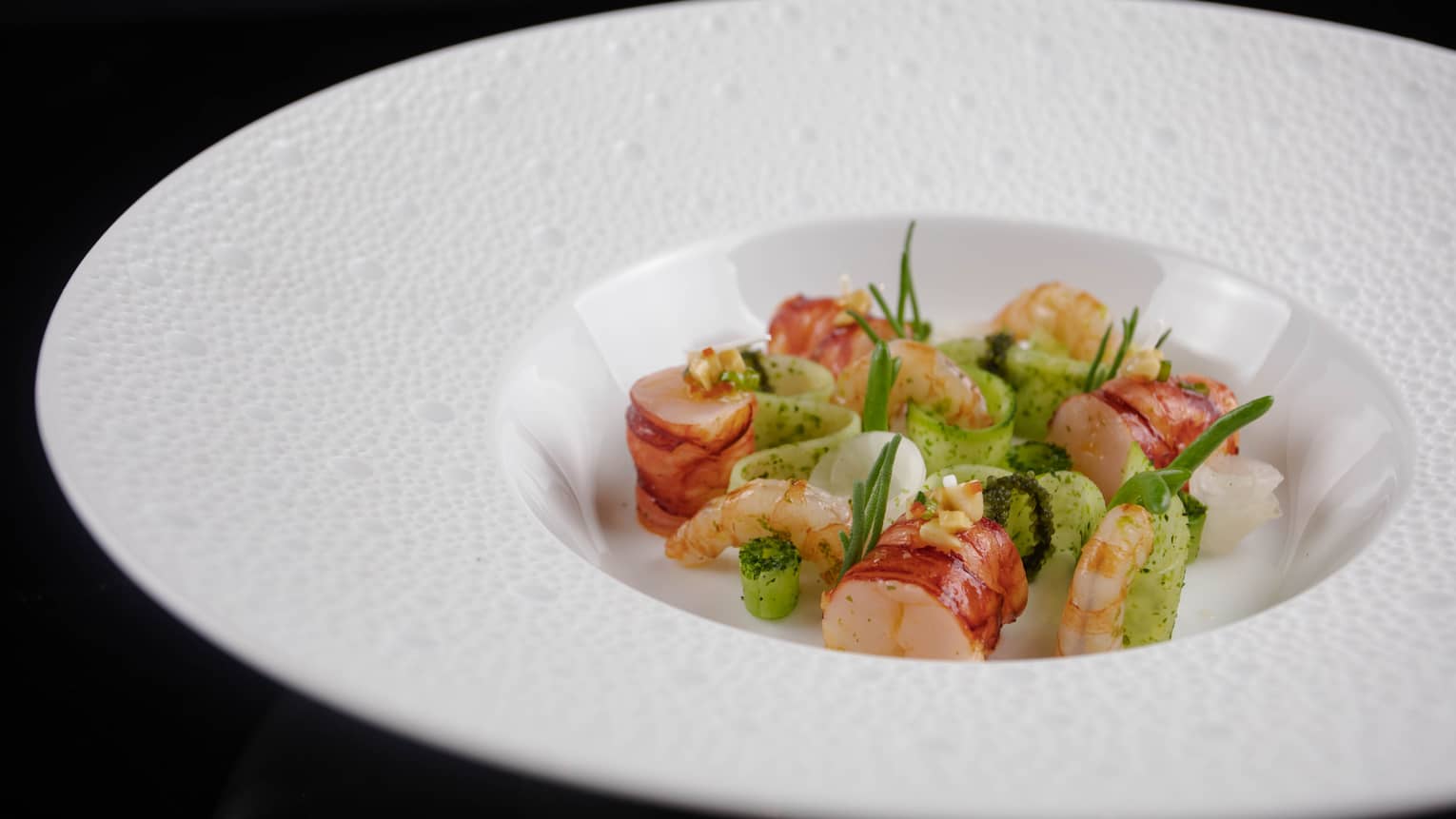Shrimp pieces and cucumber slices arranged in white dish
