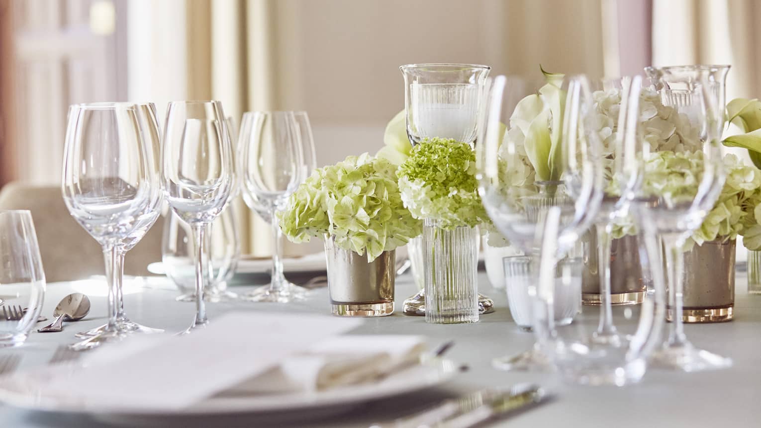 Place setting with plate, two wine glasses, one water glass, flower centerpiece