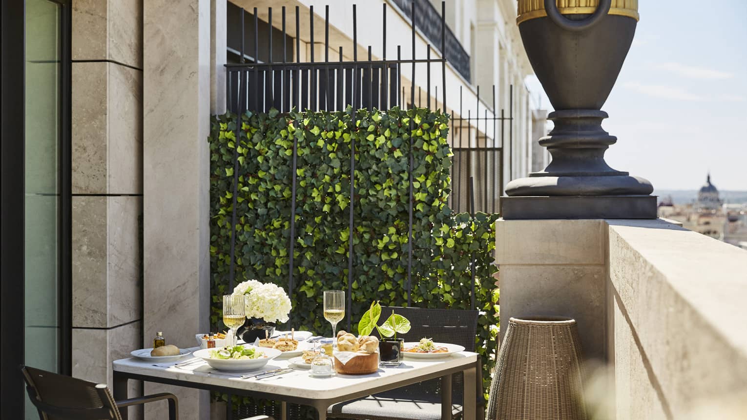 A hotel room terrace with a dining table and two chairs