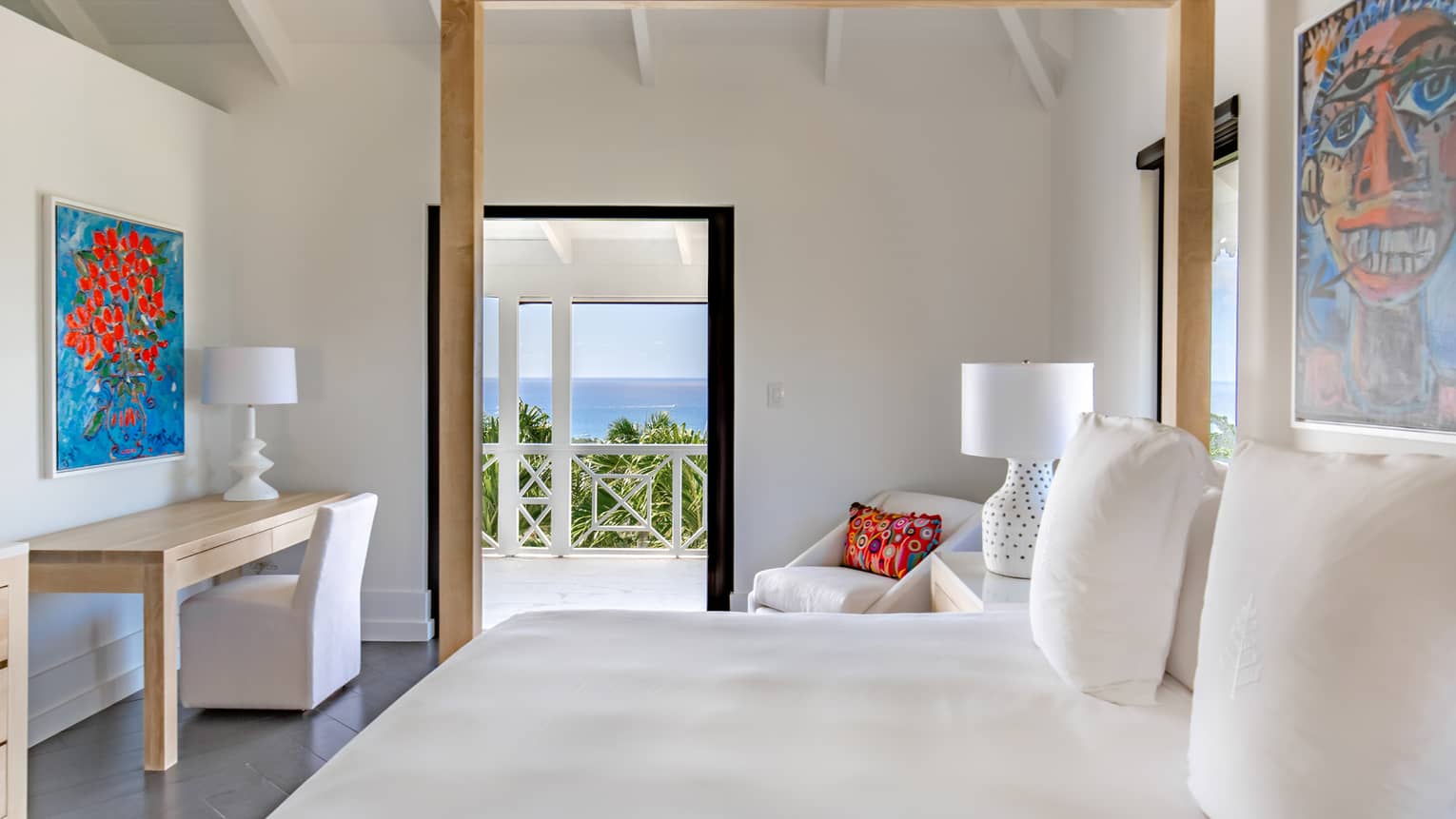 Bedroom with canopy bed, white sheets, desk and sea-view terrace