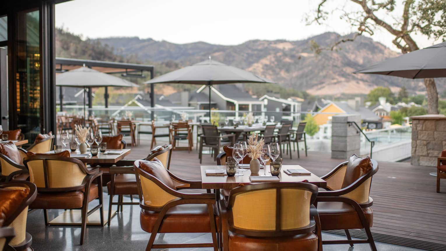 Restaurant dining room opens to wooden patio with umbrellas