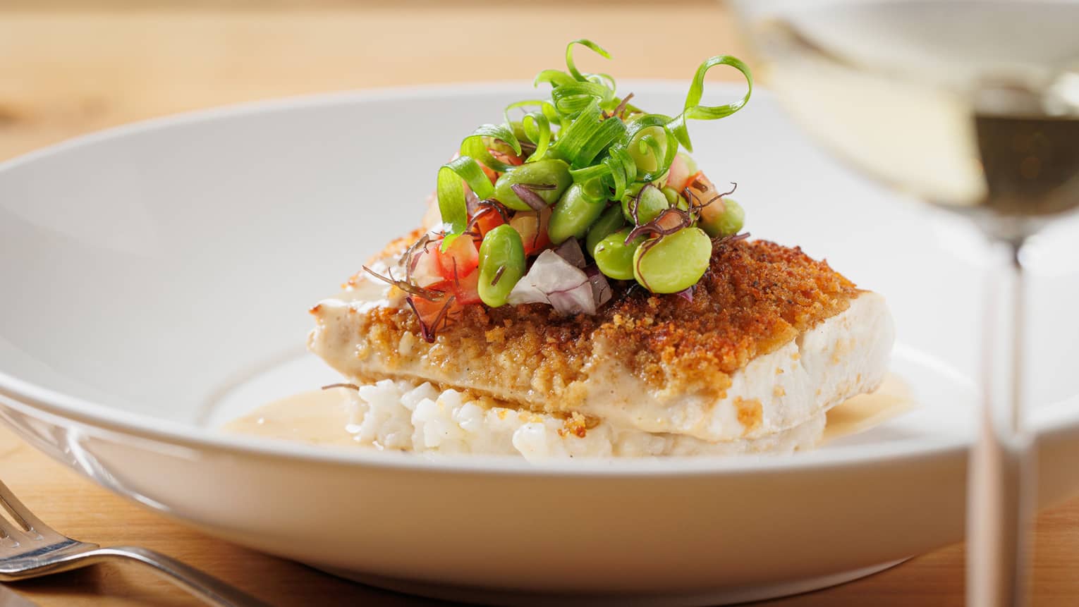 Seared white fish on bed of risotto, topped with edamame salad