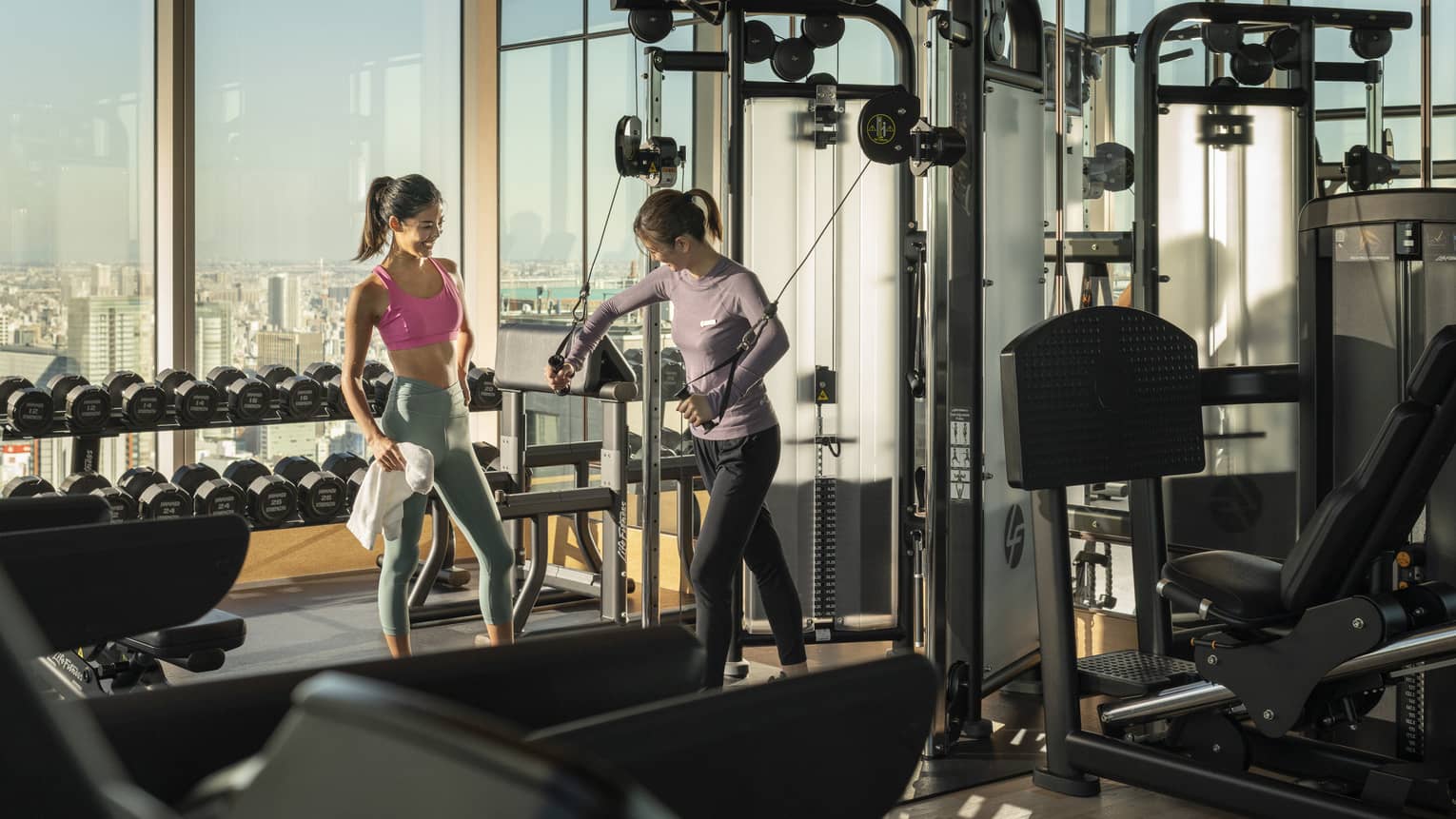 Trainer shows woman how to use exercise machine during a private session
