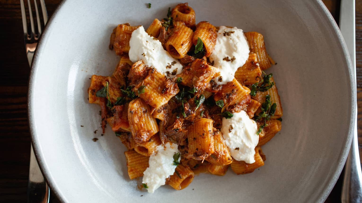 A pasta dish with creamy white cheese and a tomato sauce.
