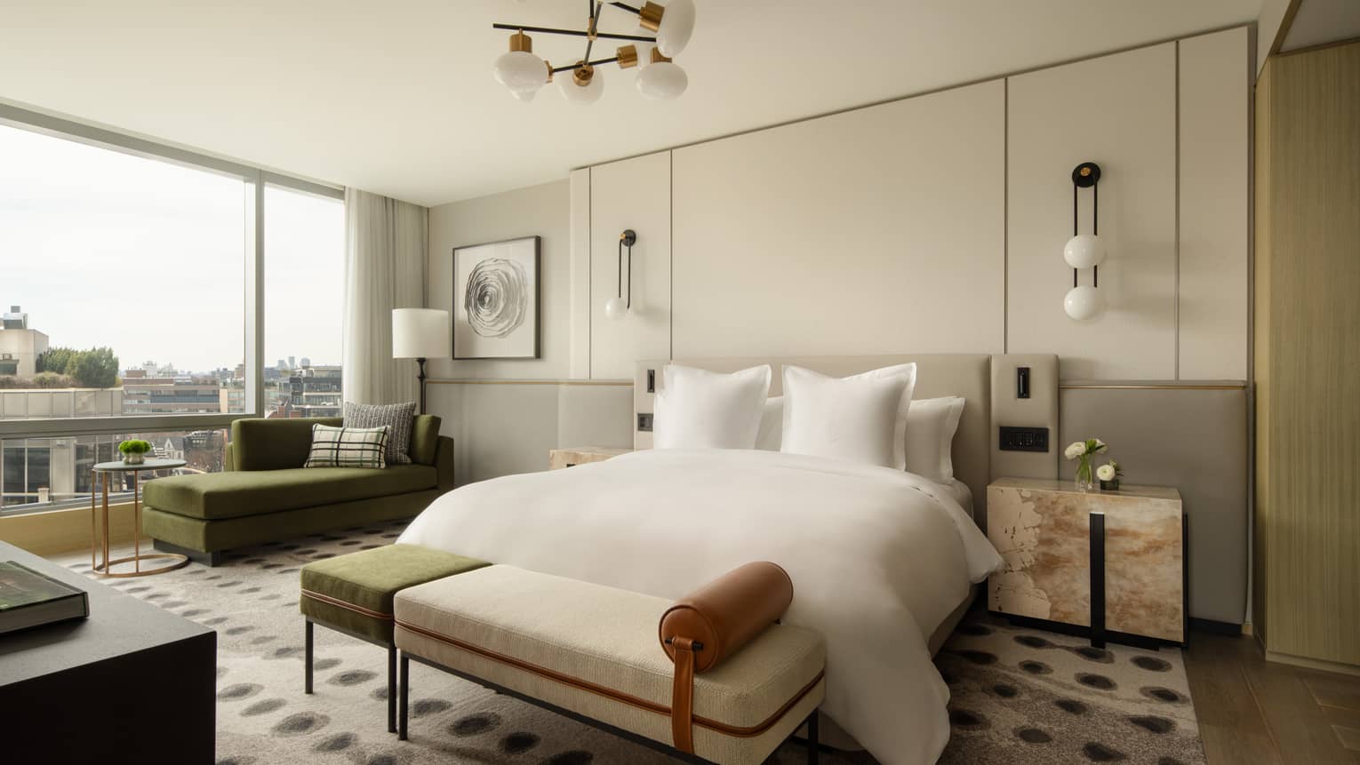 Hotel suite bedroom with king bed, bench and windowside chaise at Four Seasons Hotel Toronto