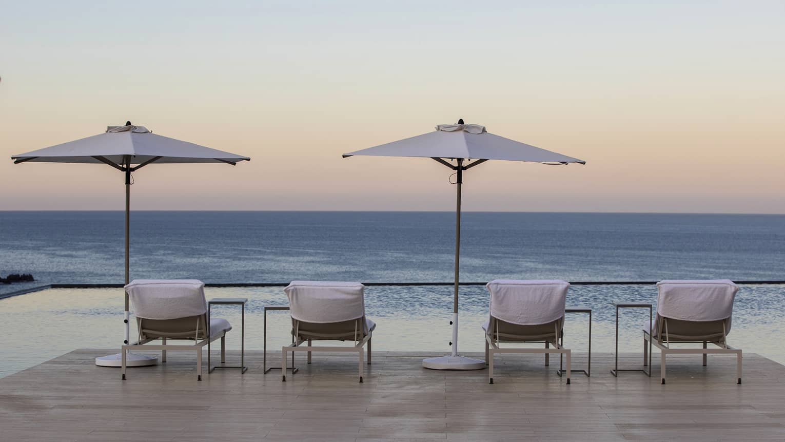 Lounge chairs and umbrellas looking out at the ocean.