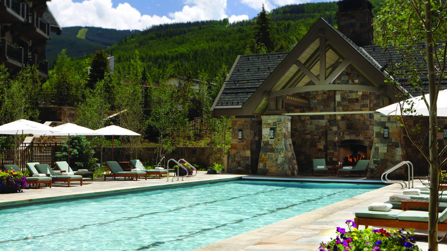 Outdoor lap pool at Four Seasons Resort Vail, lined with lounge chairs