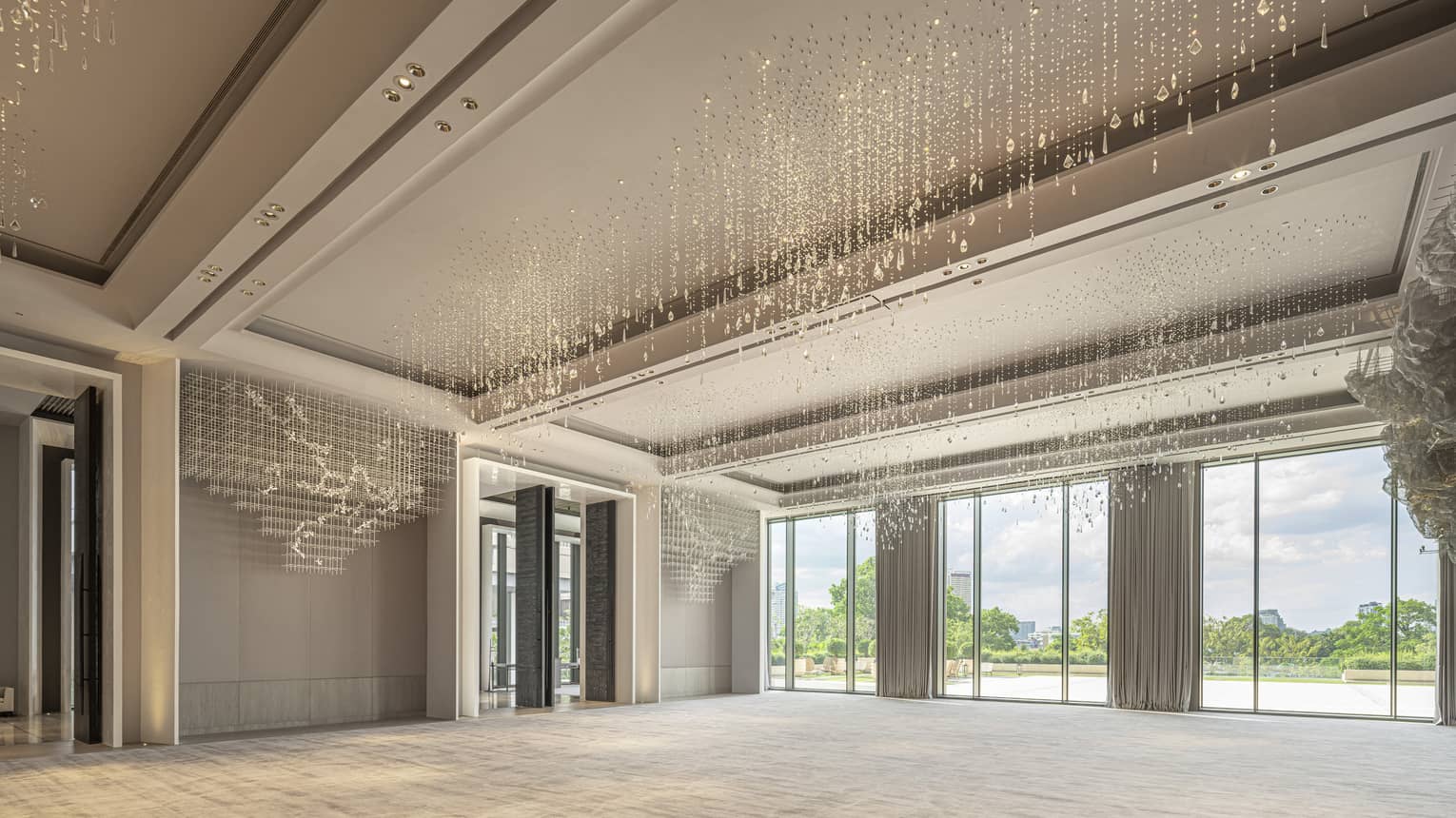 Grand Ballroom with cream-coloured carpeting and drapes, floor-to-ceiling windows and hanging crystal beads 