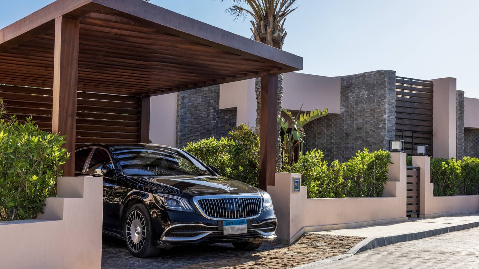 Sleek black hotel car under portico of the One-Bedroom Beach Villa