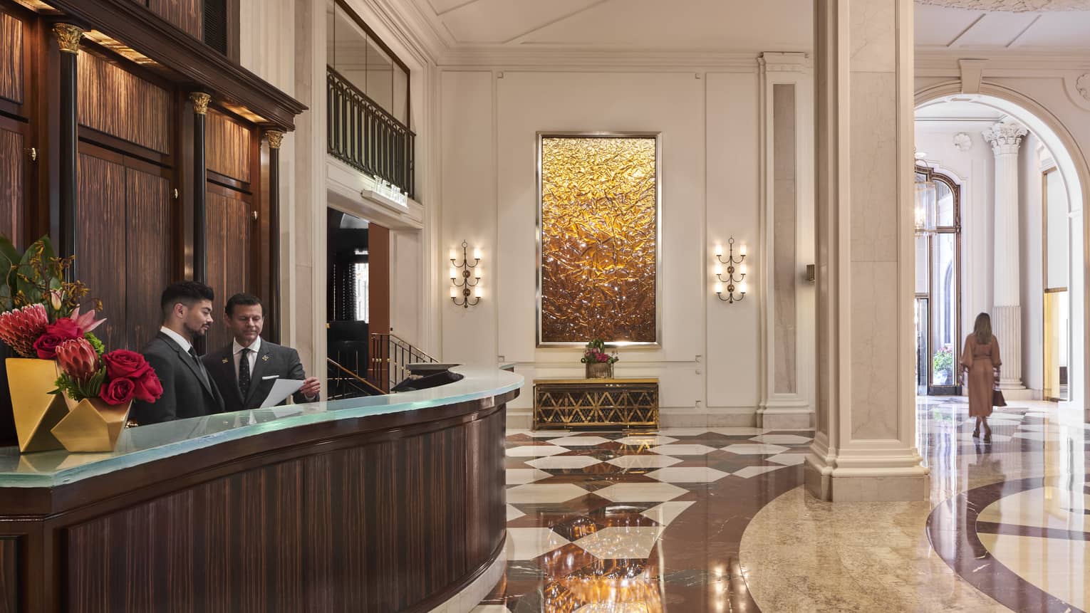 The large concierge desk of a well lit hotel lobby.