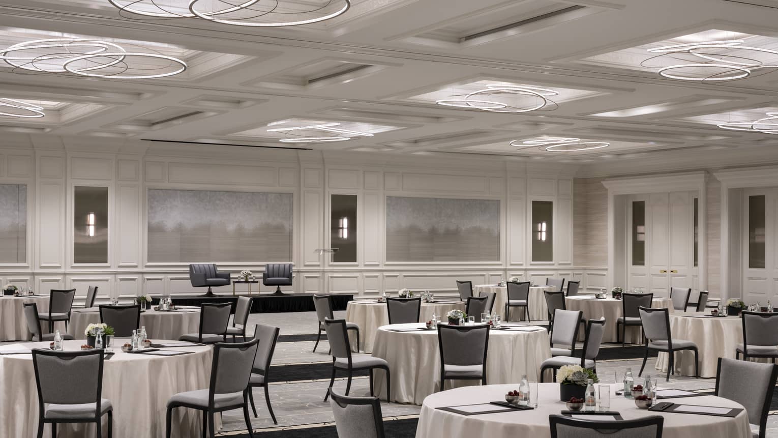 White ballroom with set round tables and muted artwork