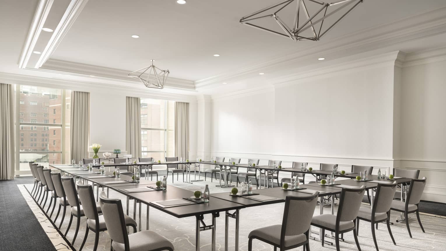 White conference room with dark tables in boardroom-style seating