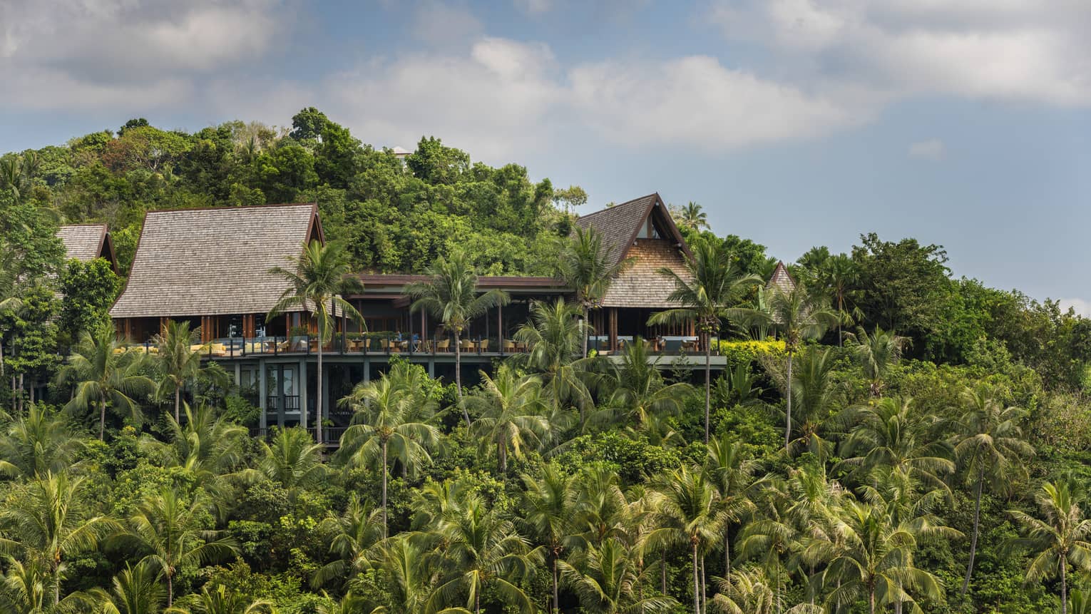 Exterior view of KOH Thai Kitchen and Bar building, perched on mountain amid tropical trees