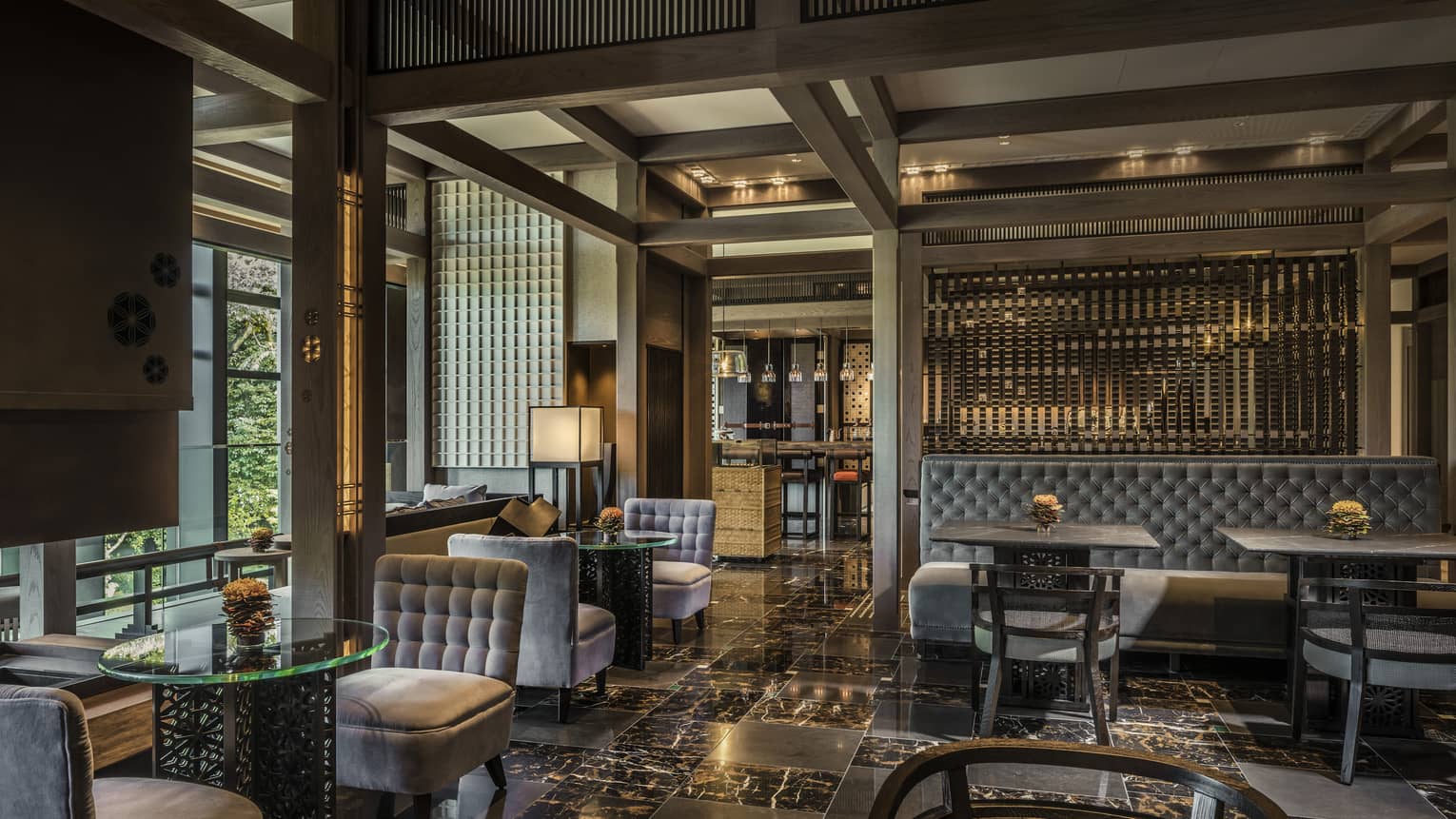 Plush grey velvet sofas, chairs on black marble floors in The Lounge dining room