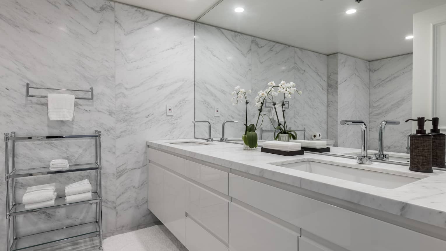 Bathroom with marble walls, white double vanity