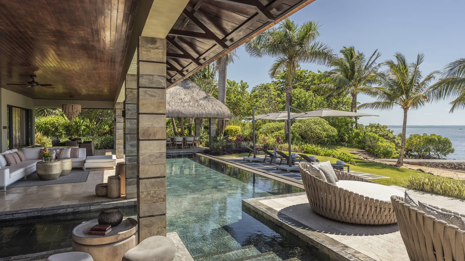 Stone, ocean-view terrace with pool, whicker day beds, pavilion covering