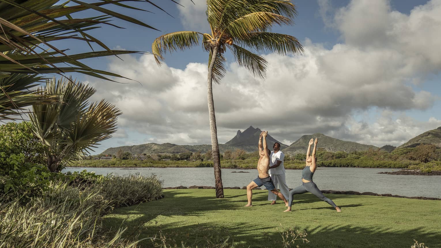Yogi teaches a couple oceanfront yoga