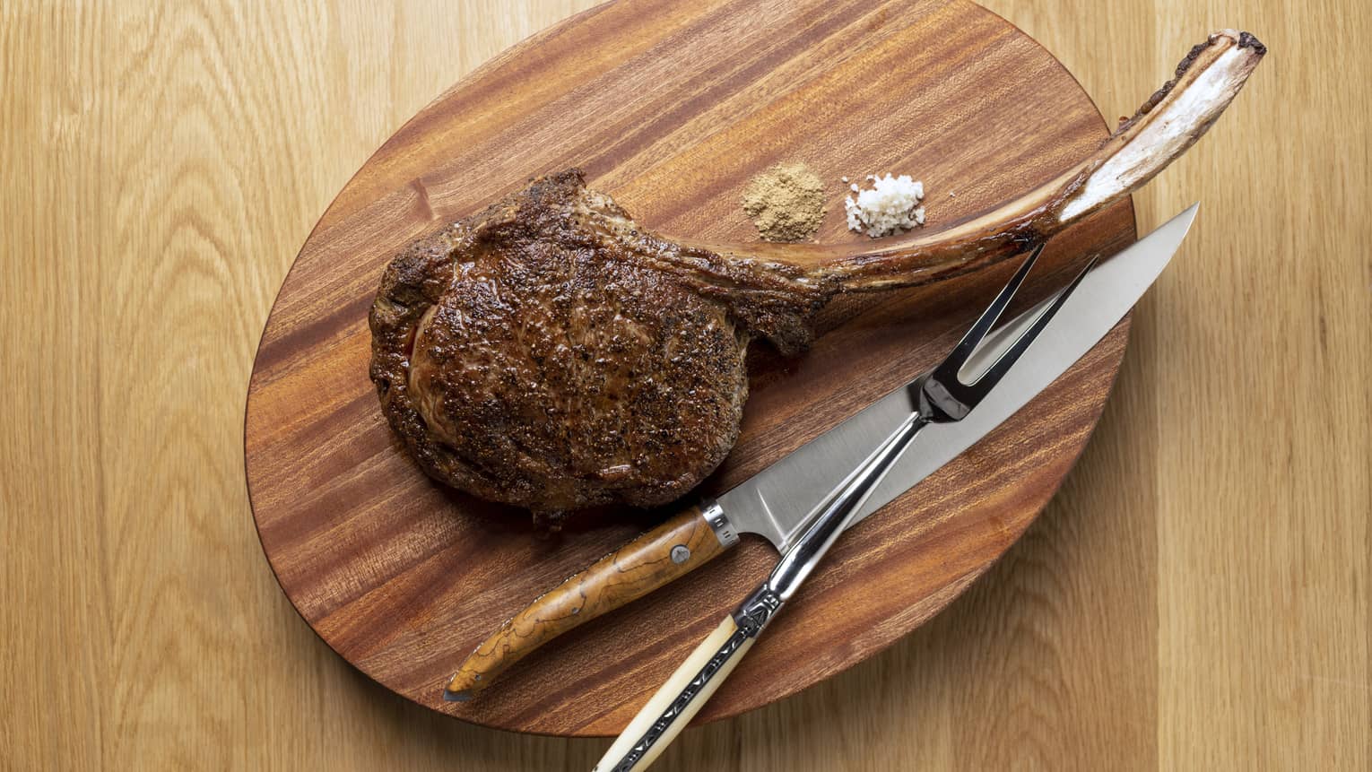 Tomahawk steak on wooden oval carving board