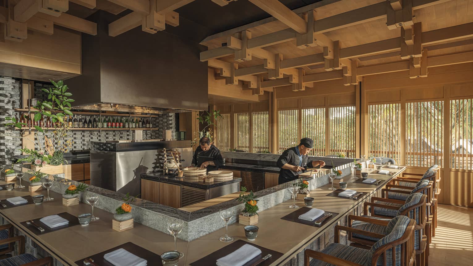 Two chefs prepare dishes behind omakase counter at bright and airy NAYUU restaurant