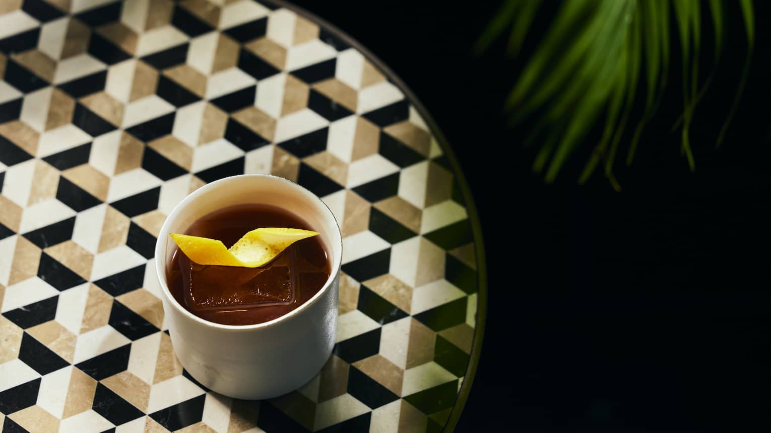 Cocktail with lemon peel on round bar table