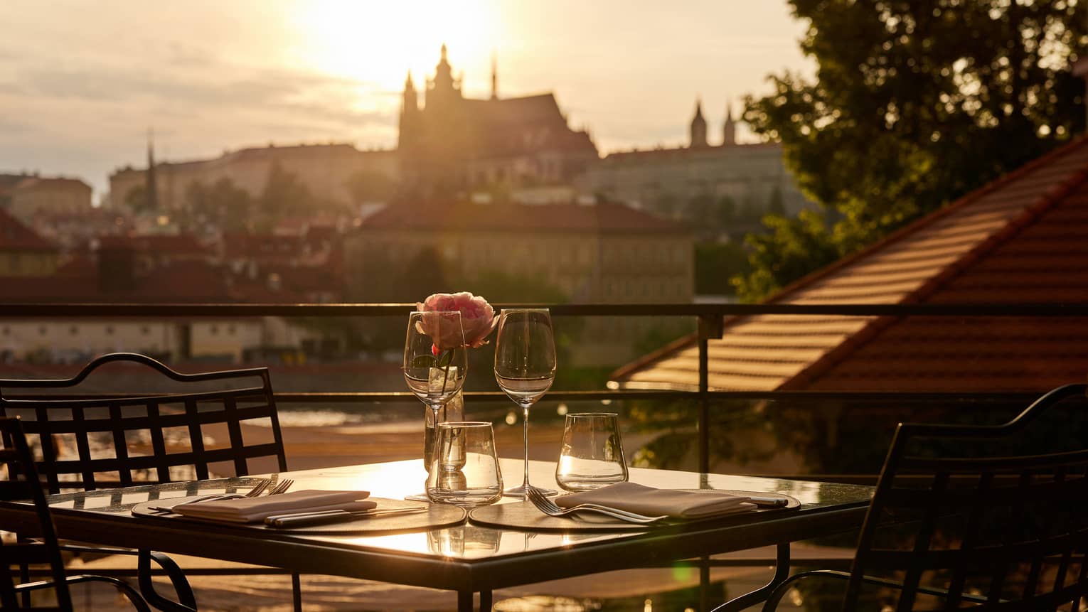 Terrace dining setup at sunset with view of Prague Castle in backdrop