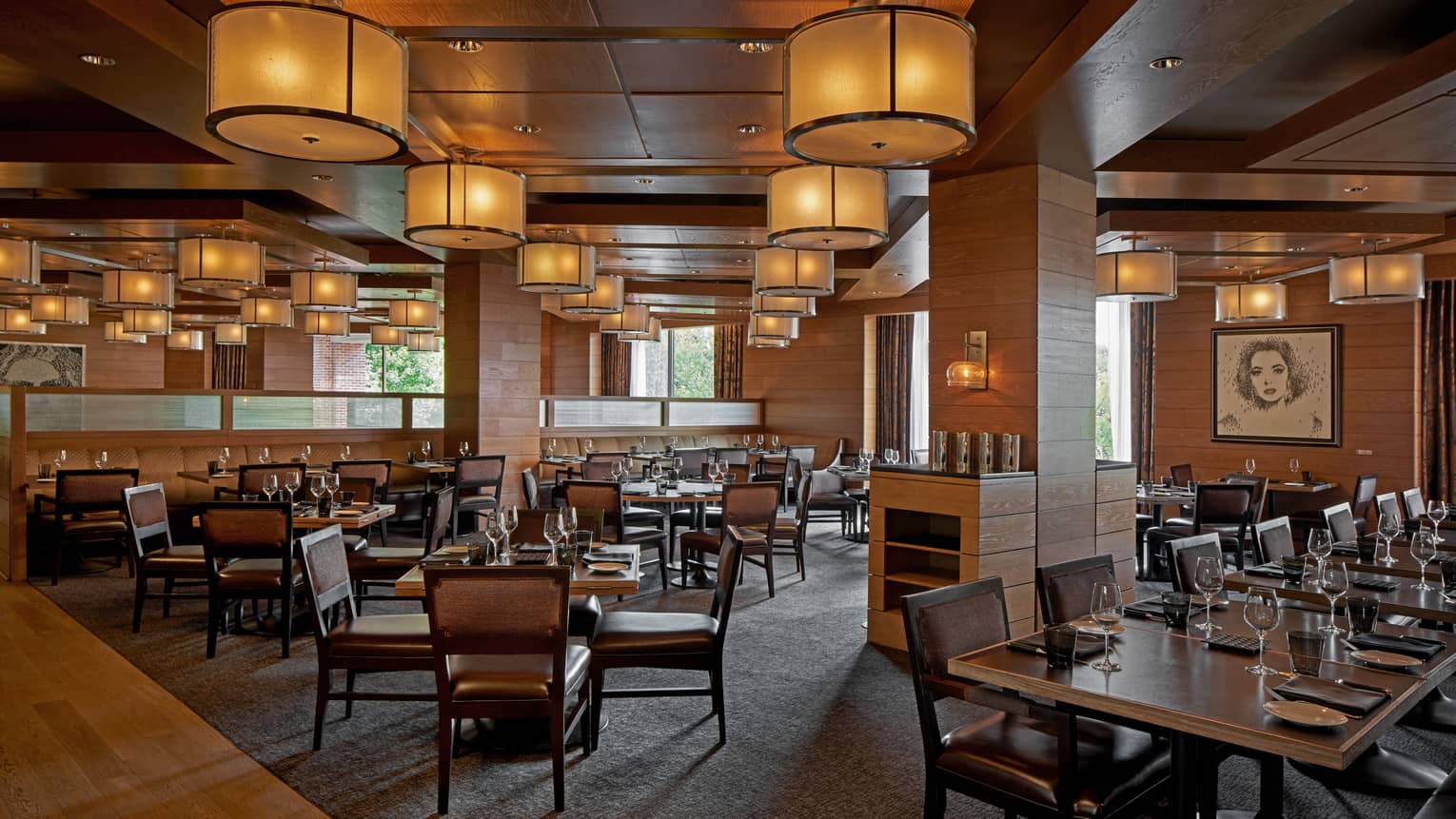 A dimly lit restaurant with large wood tables.