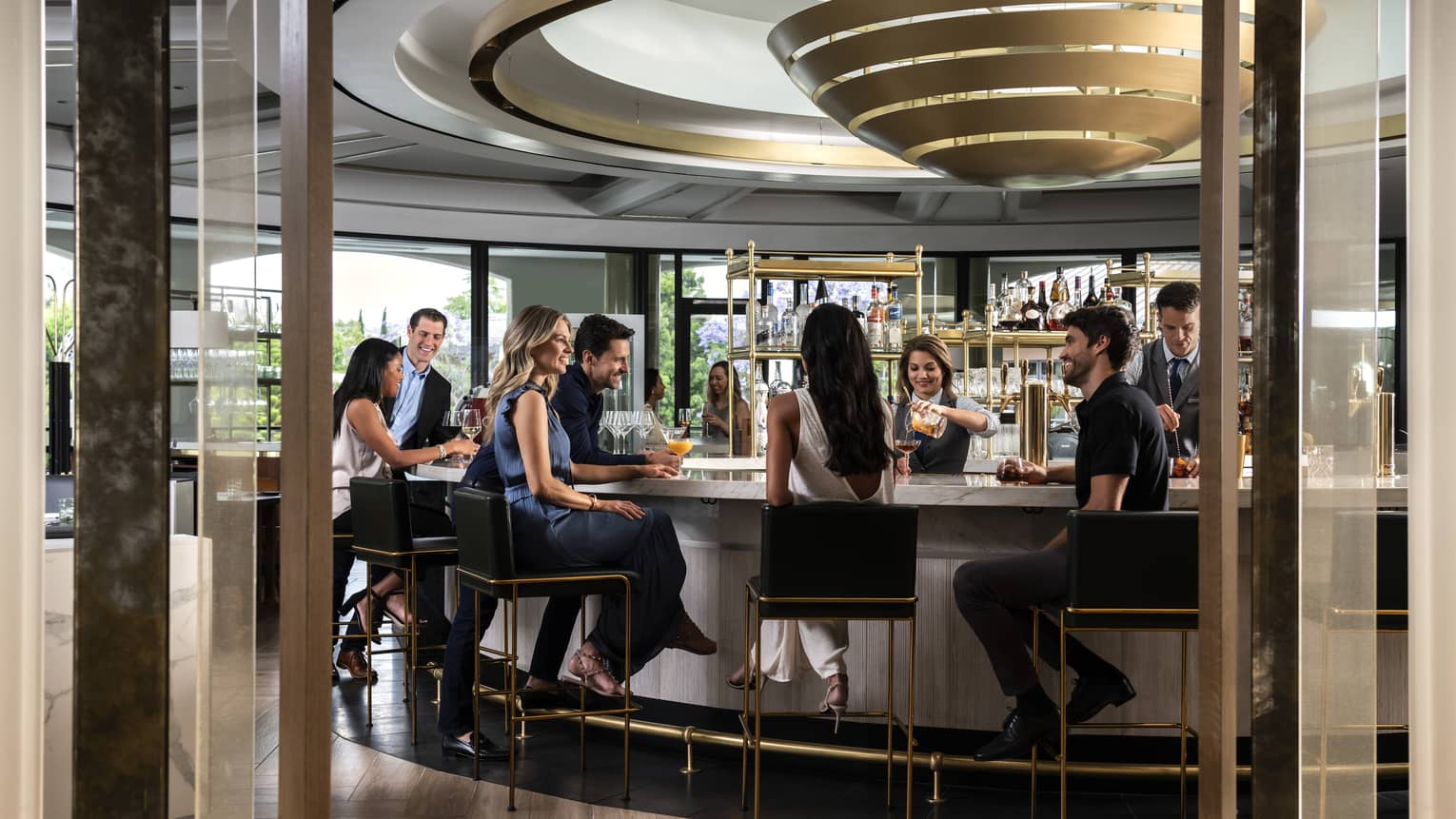 a group of middle-aged people socialize at the bar at Coin and Cander