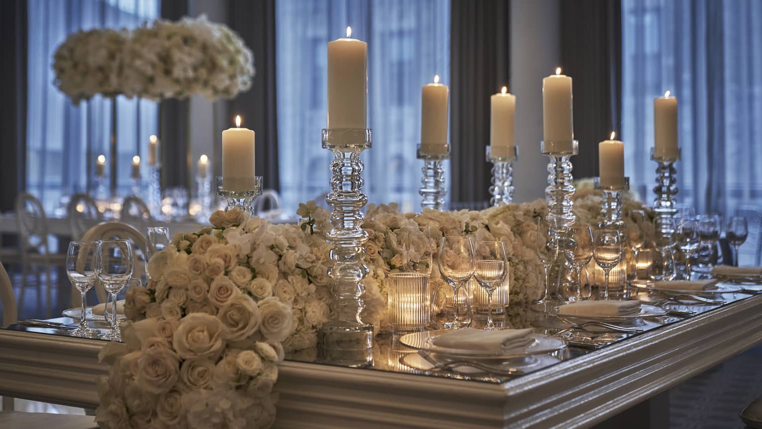 Formal white floral tablescape with lit candles in the Beacon Room.